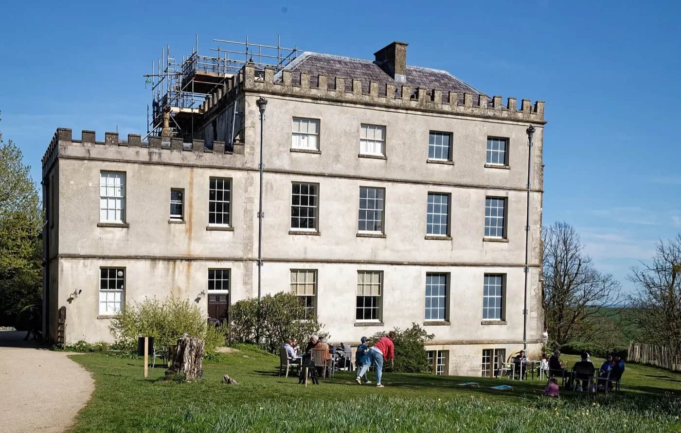 The west face of Newark Park, a honey-stone Tudor house above lawns and the Ozleworth valley
