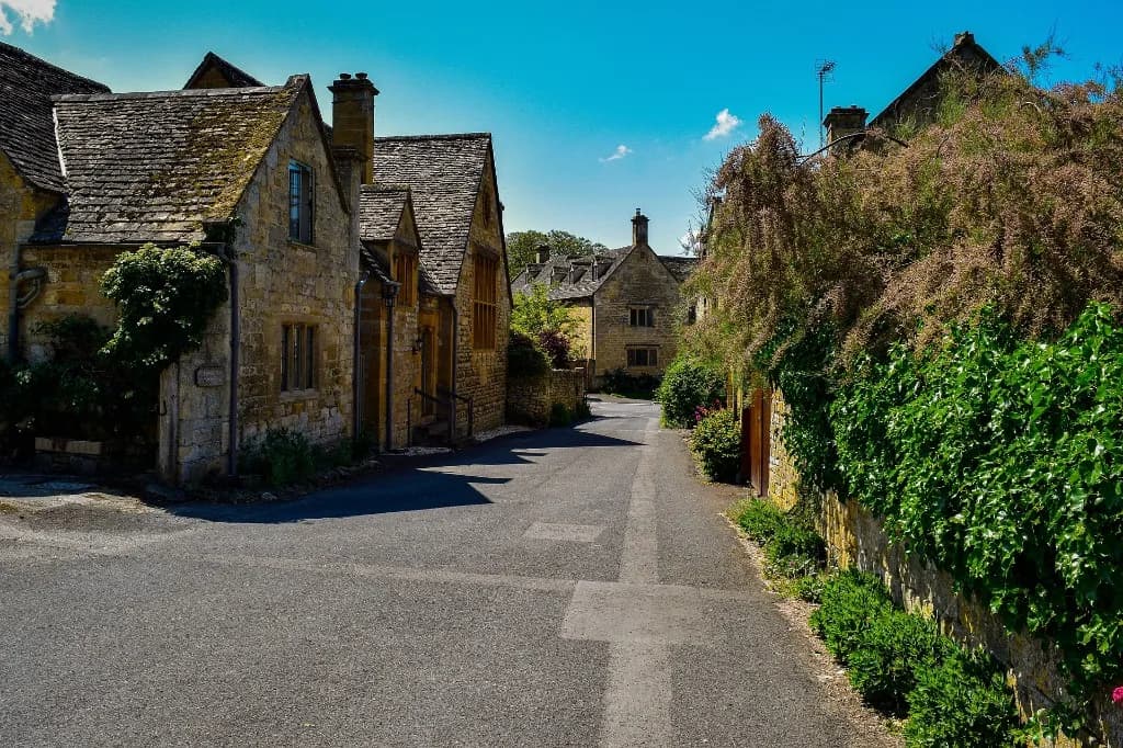 Honey-coloured Cotswold stone cottages along a quiet village street
