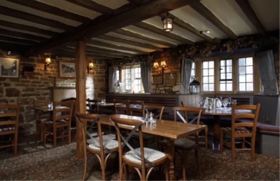 Beamed dining room with stone walls at The Eight Bells