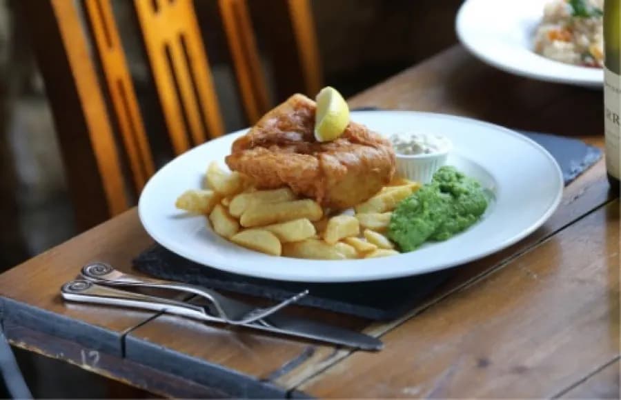 Plate of fish and chips with mushy peas at The Eight Bells
