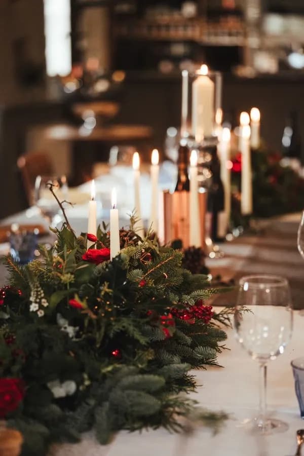 Candlelit dining table with evergreen centrepiece at The Falcon Inn