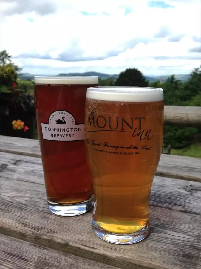 Two pints of Donnington Brewery beer on the terrace at The Mount Inn