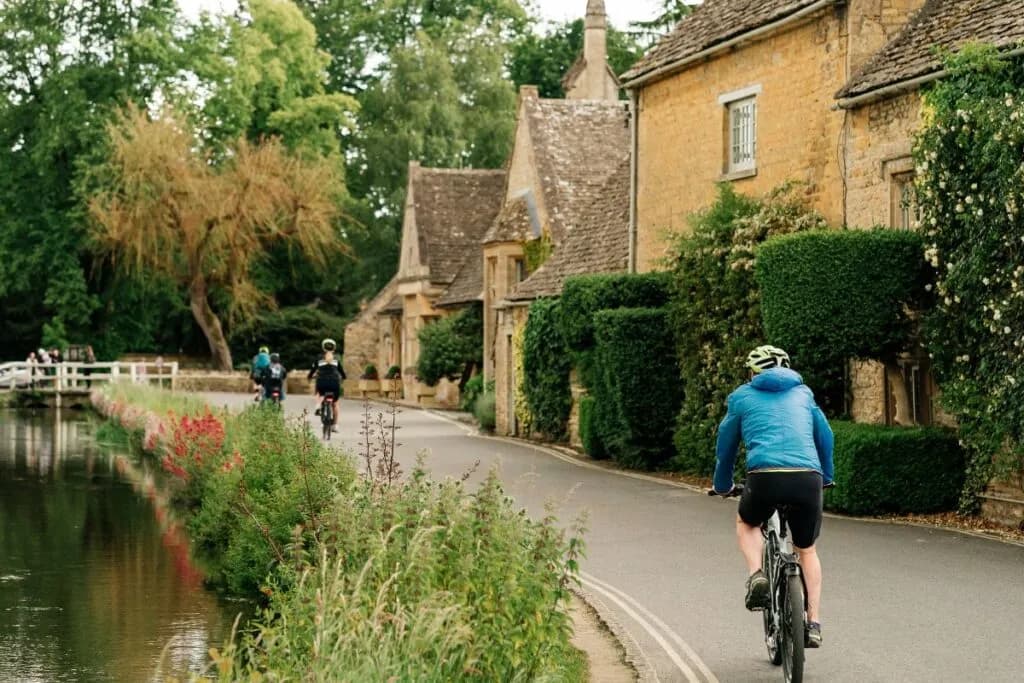 Cyclists riding through a Cotswold village