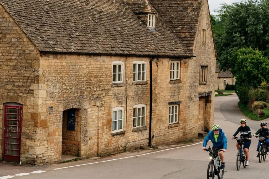 Group cycling along a Cotswold lane