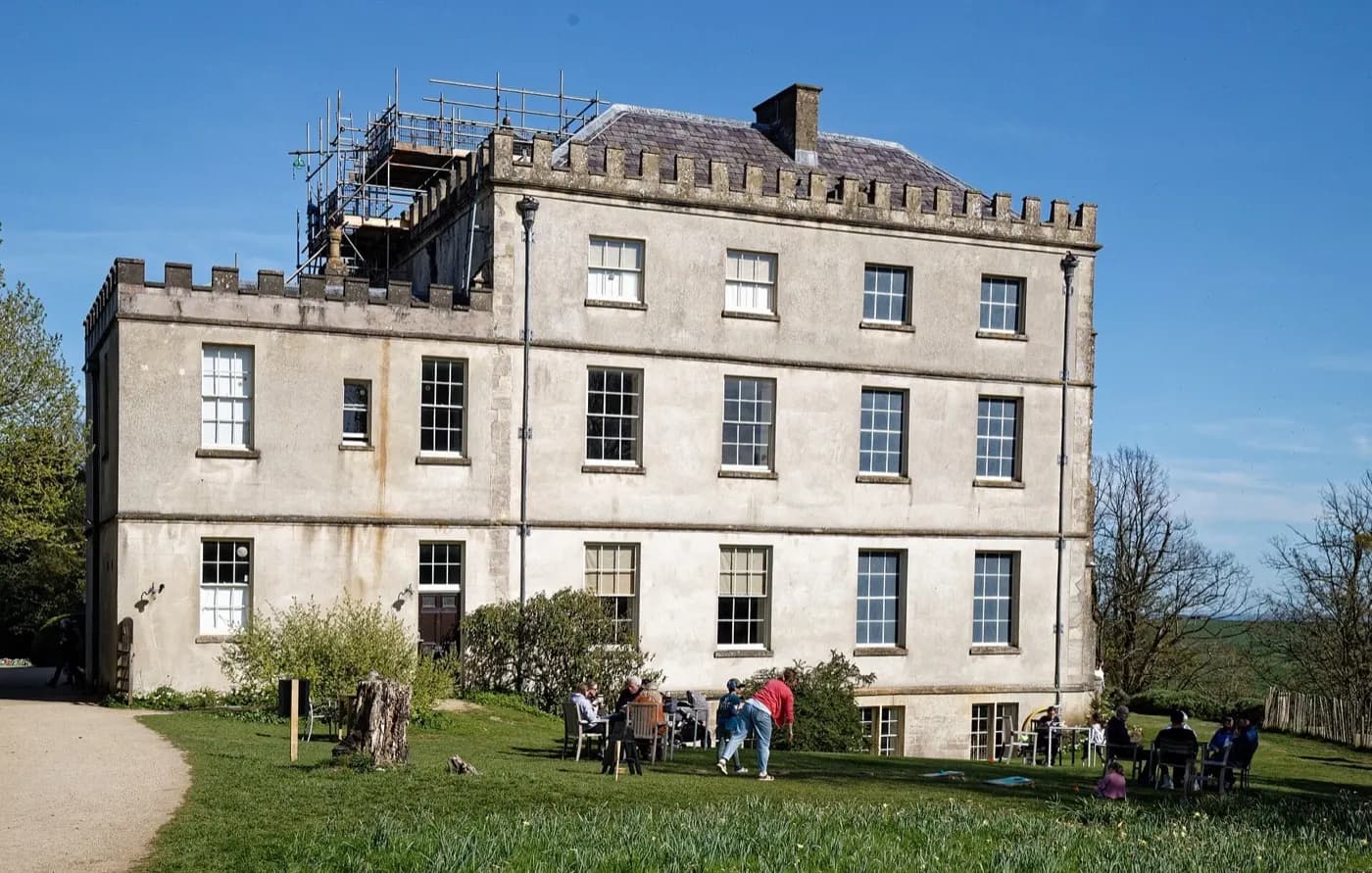 The west face of Newark Park, a honey-stone Tudor house above lawns and the Ozleworth valley