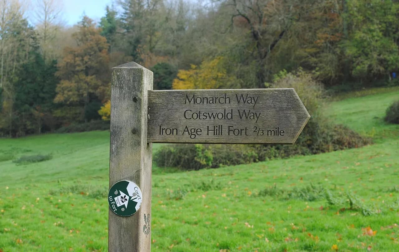 Wooden Cotswold Way and Monarch's Way fingerpost with National Trust waymarker