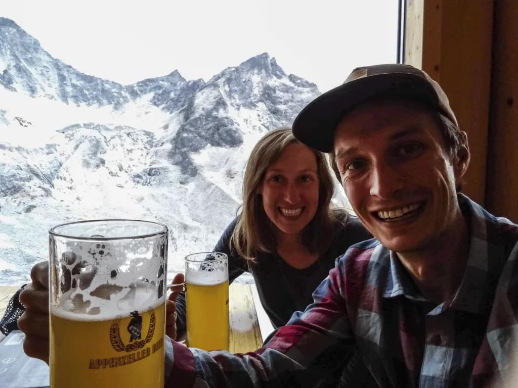 Ian Swallow and Emily smiling indoors with mountain views behind them