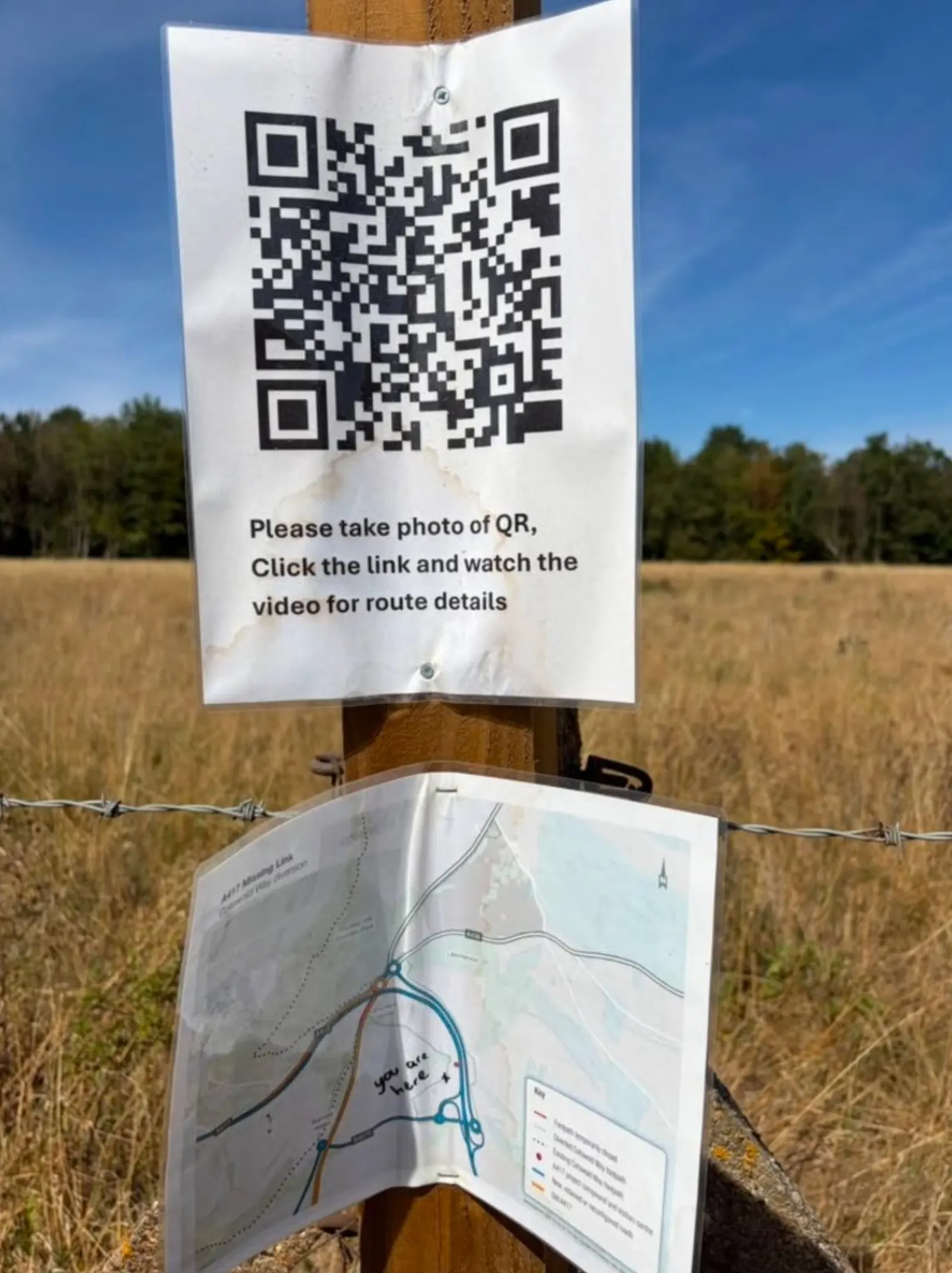 Trail post with a QR code asking walkers to watch a video for route details, and a laminated A417 Missing Link map marked you are here